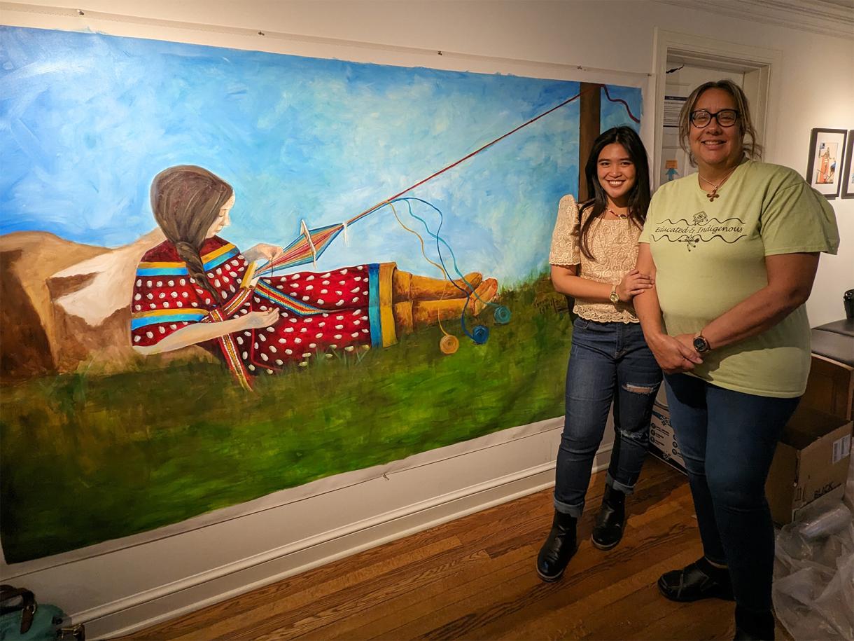 artists Venazir Martinez and Karen Lynch Harley stand next to a mural painting in the John Hope Franklin Center