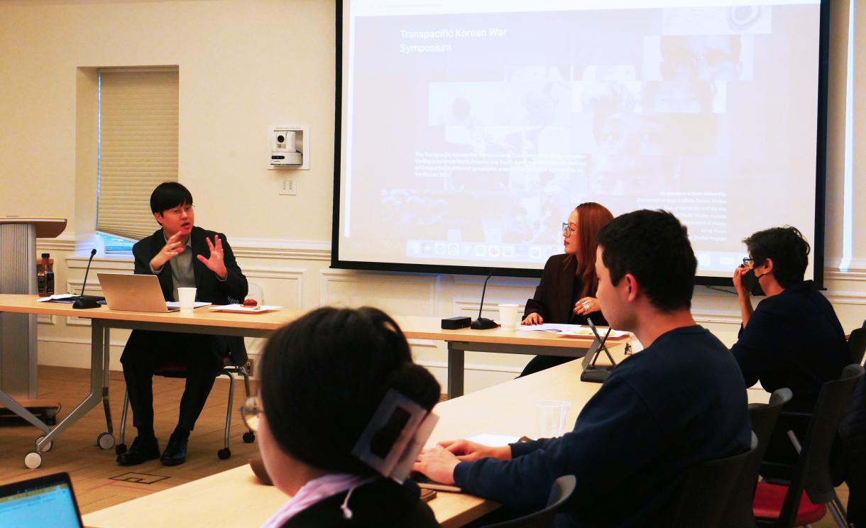 People sitting at tables during a symposium