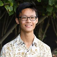 a person wearing glasses and a light shirt with a tan leaf print
