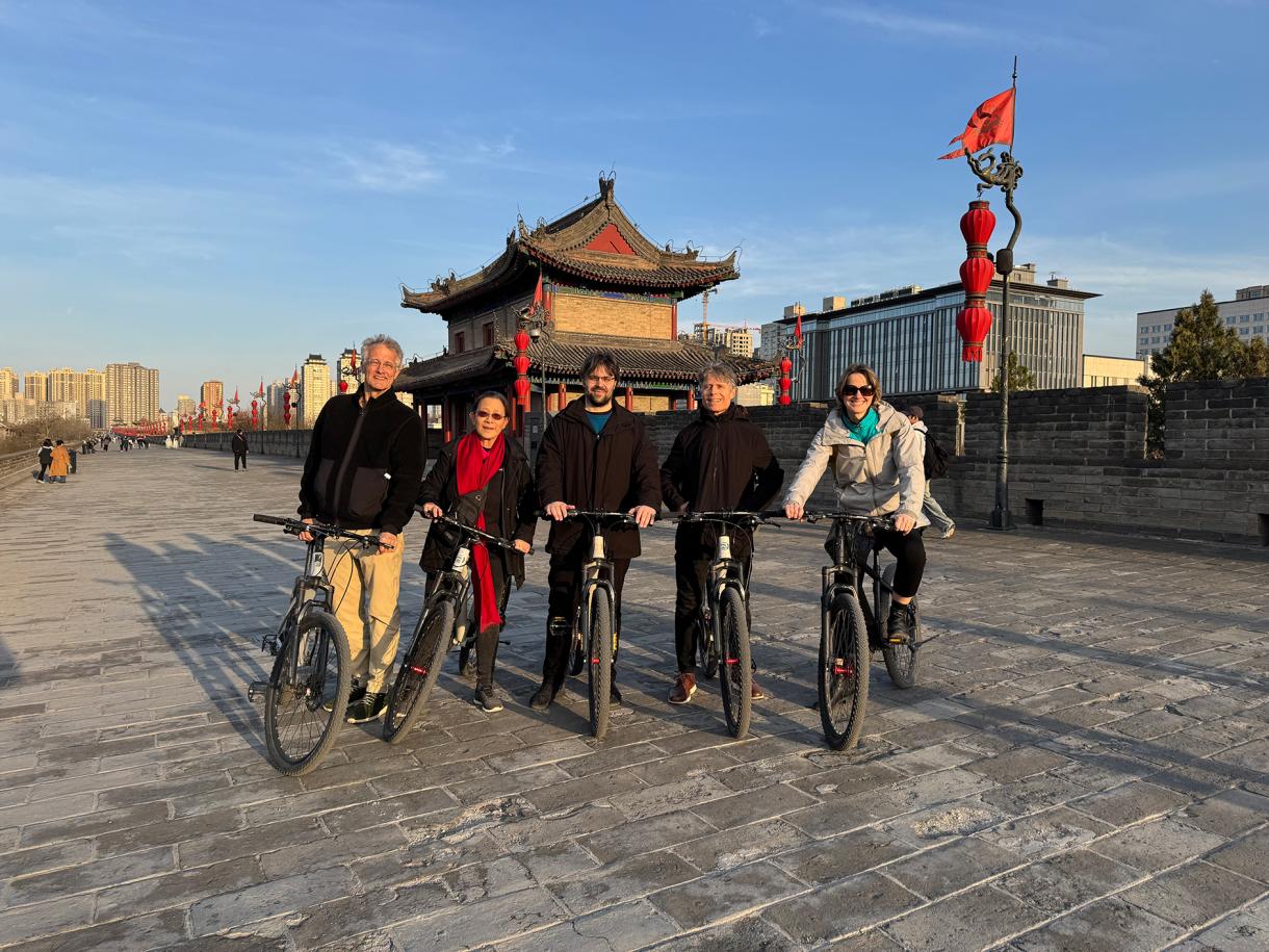 Five people riding bicycles along the Xi'an city wall