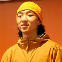 Headshot of a person wearing an orange jacket and hat