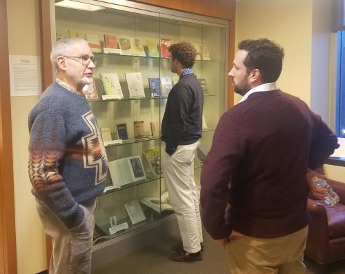 People standing near a display of books in the East Asia Collection of the Duke Library