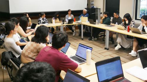 Students and faculty seated around a classroom