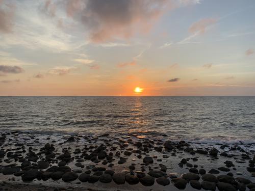 Sunset over the ocean with a rocky shore