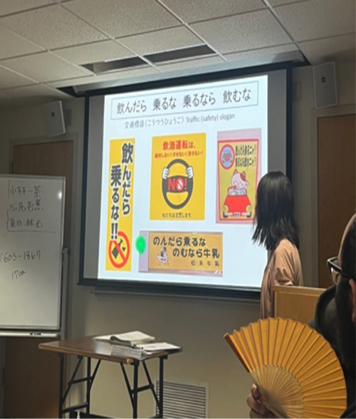 A person looks at images of Japanese-language traffic safety signs projected on a screen